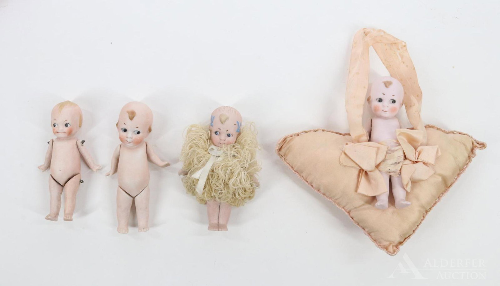 LOT OF ALL BISQUE DOLLS.: Lot of (4) German dolls with painted side glance eyes. (3) Little Imp style, (1) is unmarked and has the blue upside down bows painted in hair. (2) Marked 10383. (1) Mounted on silk pillow. The fourth