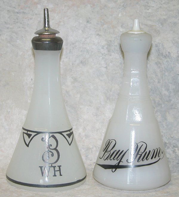 Two Clambroth Glass Barber Bottles.: Two Clambroth Glass Barber Bottles. One bottle of molded clambroth glass with square banded decoration, black script label, "Bay Rum", ceramic and cork stopper, embossed mark on bottom, "M.A. Co.", 7