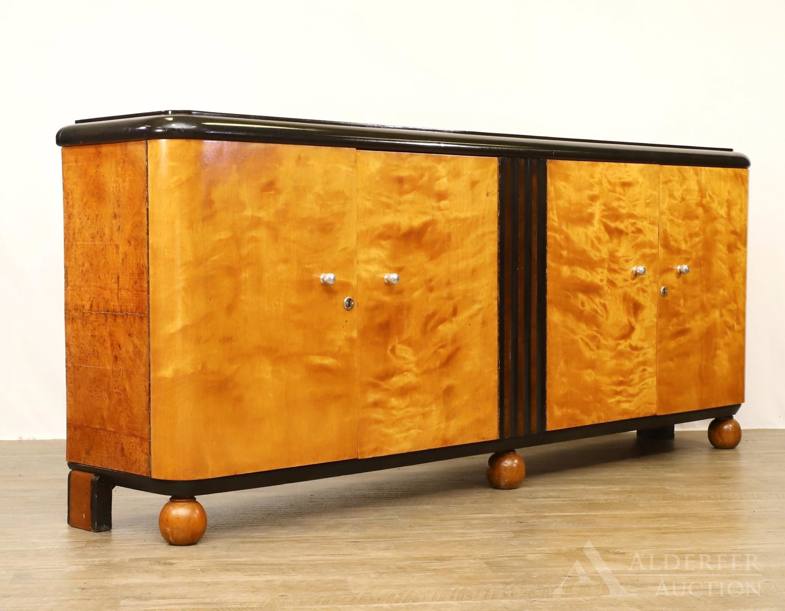 Art Deco Credenza: Maple and walnut veneer, double sided two doors with one set opening to shelving and the other set opening to two short drawers over two long doors on bun feet. 36"h x 84"w x 17"d