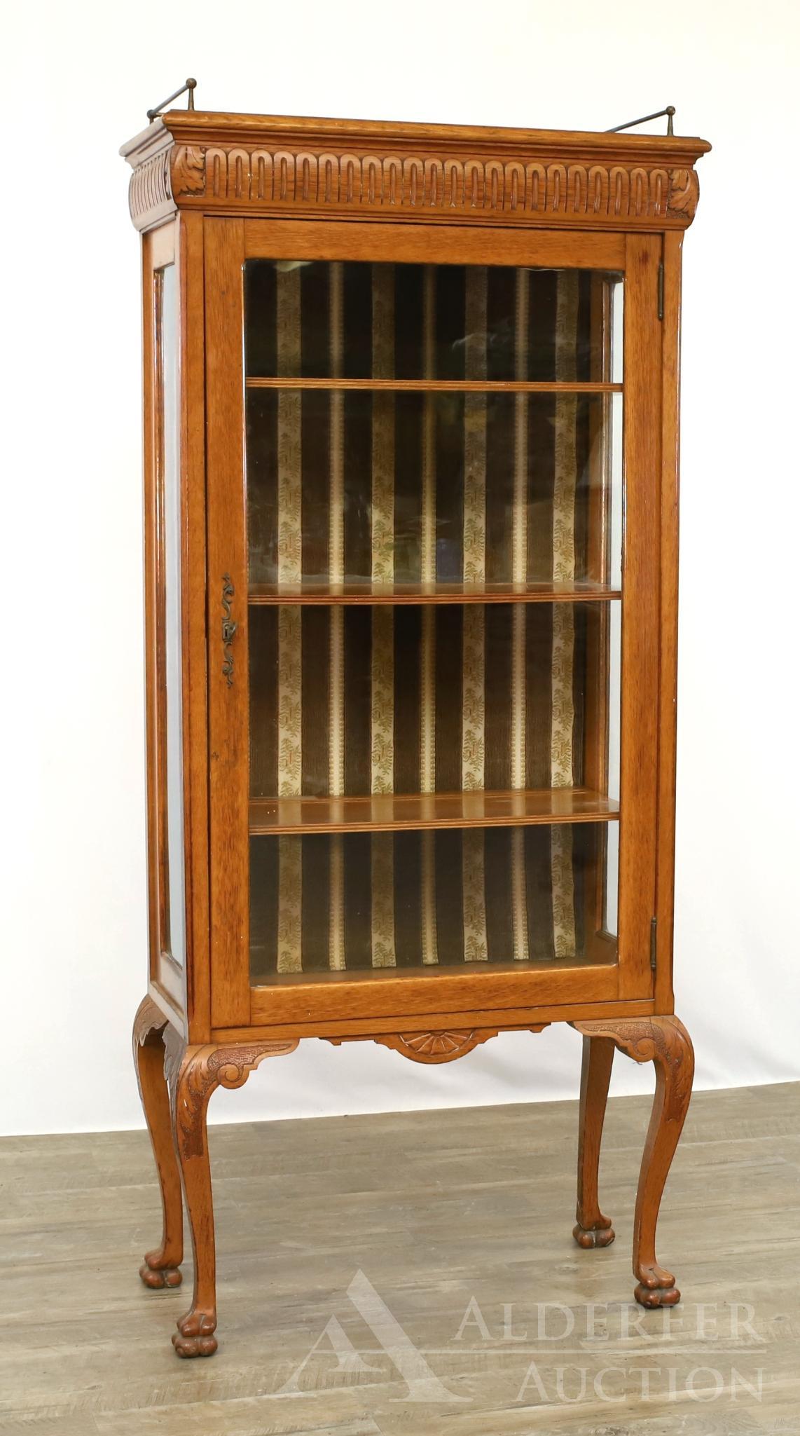 Carved Oak China Cabinet: 19th c. Brass gallery with a repeating motif carved cornice, one door, acanthus knee ls and paw feet. 63"h x 28"w x 13.5"d