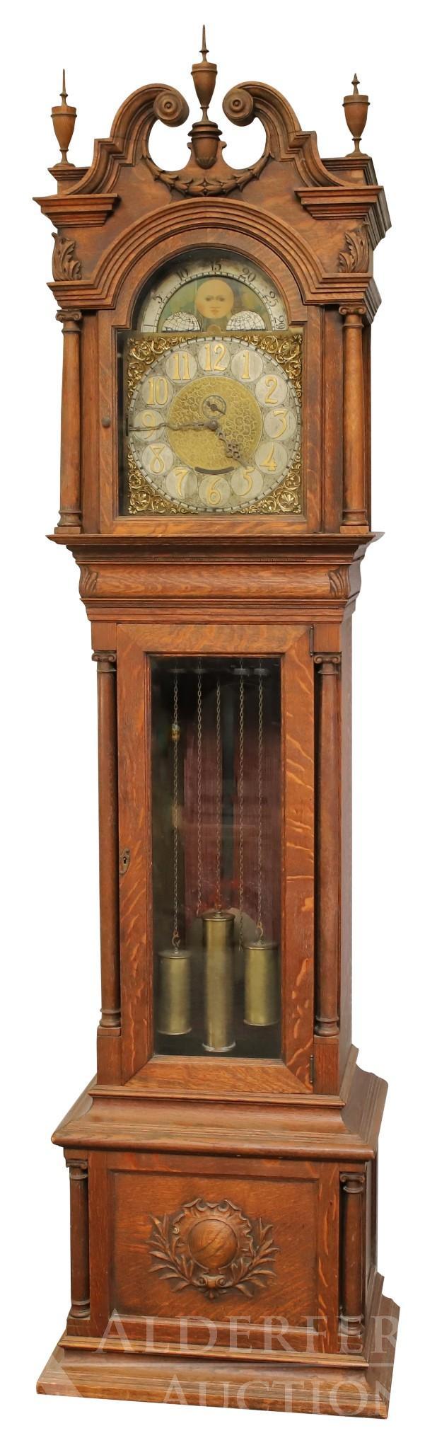 John Wanamaker Ornate Carved Oak Tall Case Clock: 19th c. Oak case consists of the bonnet having a broken arch pediment with festooned fruit and vine decoration, molded cornice and arched door and pierced side panels. Capital columns along the bonnet
