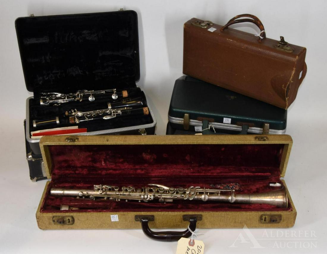 5 Plastic and 1 metal Clarinets: 6 clarinets. In need of refurbishment. Playable. From makes: Cavalier (metal), Bundy Resonite, Pemier by Pedler, and Vito. All with hard cases and accessories.