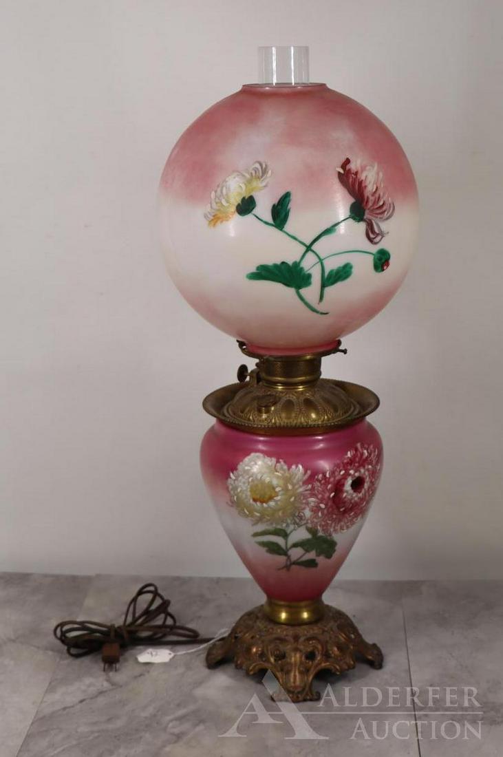 Gone With The Wind Lamp: Milk glass with painted flowers and magenta accents, brass mounts, bronze patinated foot, electrified. Turns on. Some fleabites to the shade rims. 27.5"h