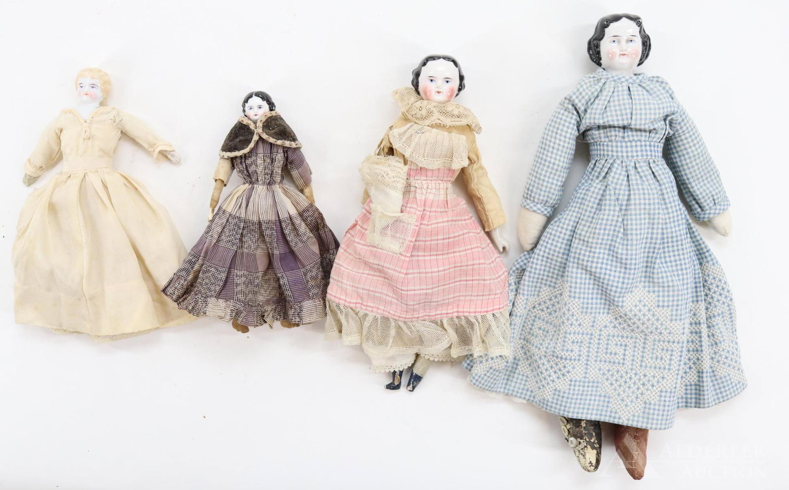 LOT OF CHINA DOLLS.: Lot of (4) dolls with blue eyes, wearing antique clothing. 8" Blonde "1" Low brow with china/parian lower limbs. Condition: right hand has been repaired. Newer cloth body. 7 1/4" Doll with black cente
