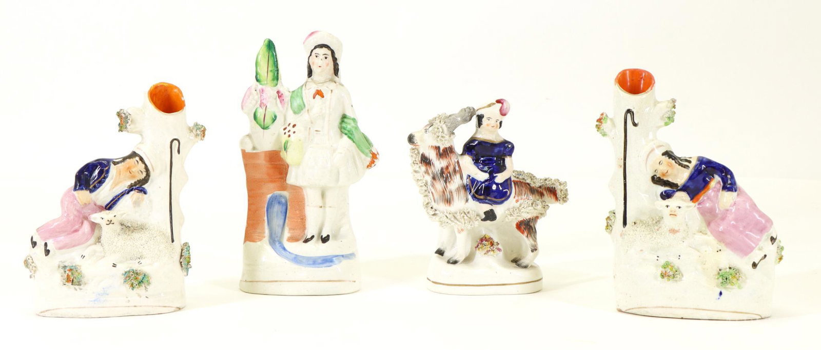 Staffordshire Figures & Spill Vases: English pottery including sleeping shepherd and sleeping shepherdess spill vases, girl on a goat figure, and a Scottish Highlander figure. The figures have repairs and touch-ups. Crazing and some firi