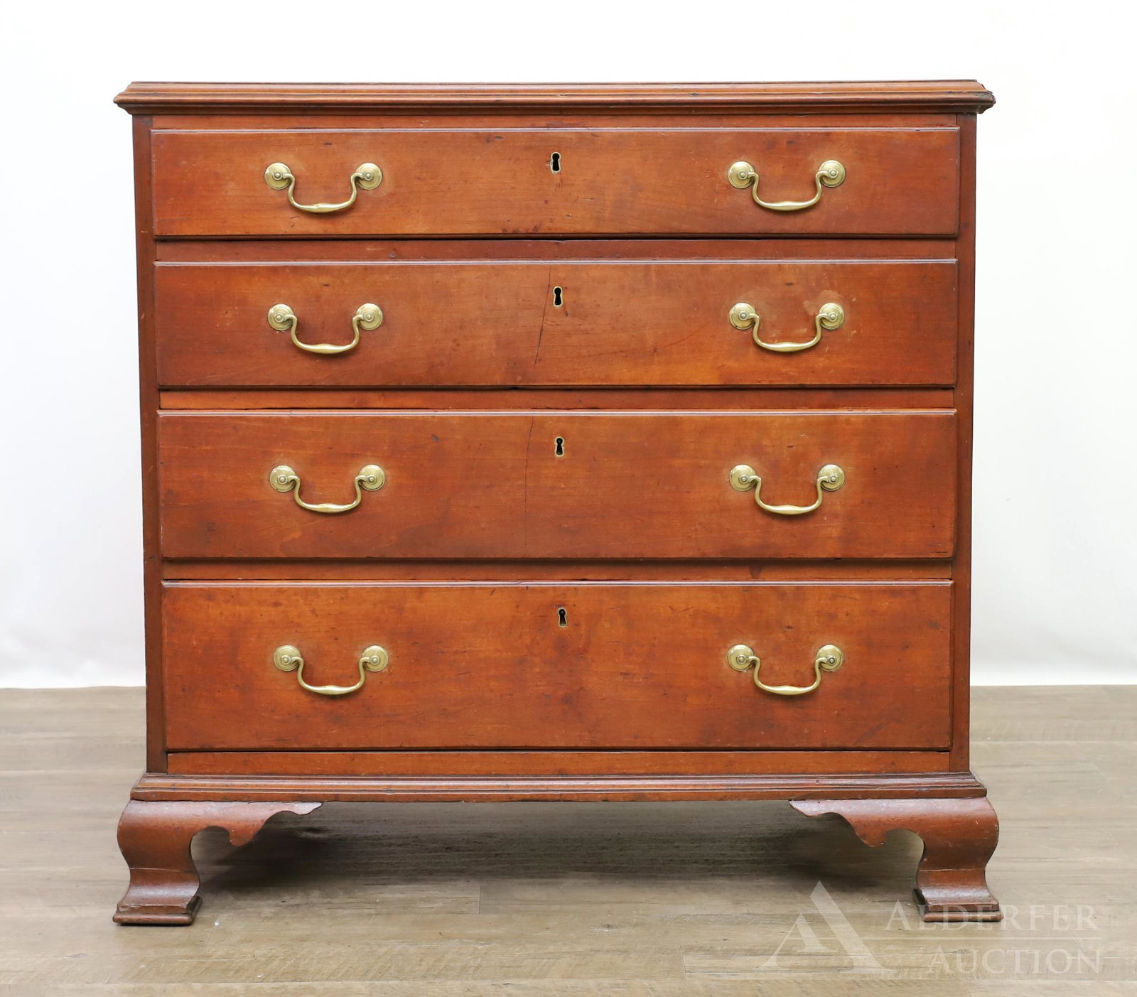 Chippendale Low Chest of Drawers: Cherrywood case. Chamfered top with four graduated drawers on original ogee bracket feet. Watermarks are present to the top of the case. 35.5"h x 36"w x 20"d **Please Note: This item is NOT eligible f