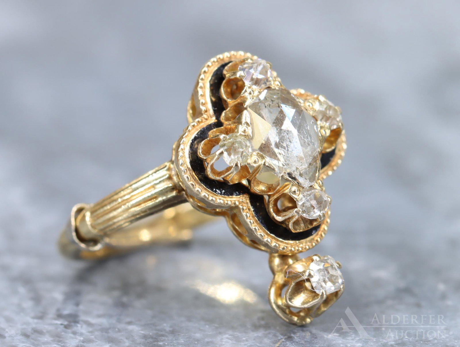 Victorian 18KY Gold Diamond Ring: Featuring a central full rose cut 7 x 5mm pear shape diamond accented by (5) mine cut 2.5mm "round" cushion shape diamonds. Black enamel outline accentuates the quatrefoil design. 17.5mm wide, size 4.