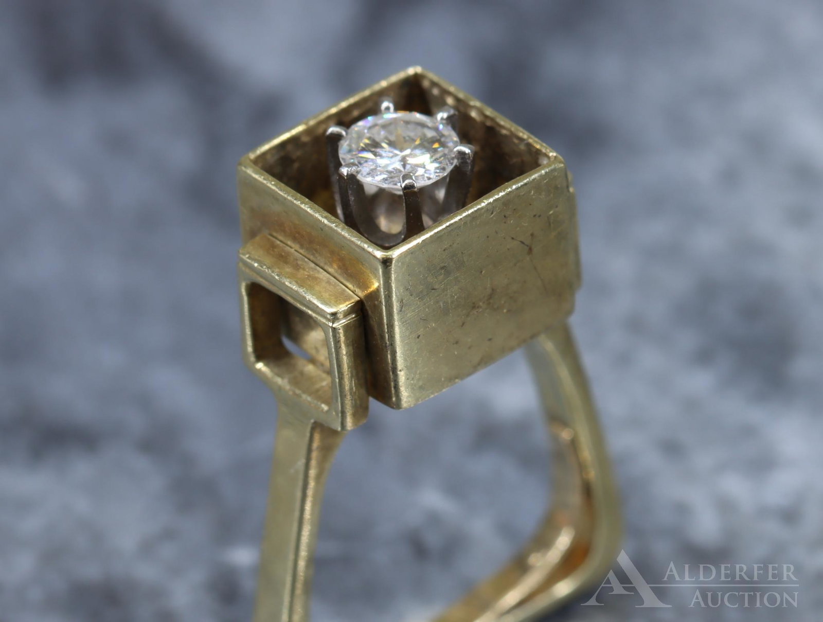 14KY Gold Diamond Ring: Modern ring design features a shadow box with a 5.4mm round brilliant cut diamond, approx. .62ct, in a 6-prong white head raised flush with the surrounding box. Arched shank has a squared bottom