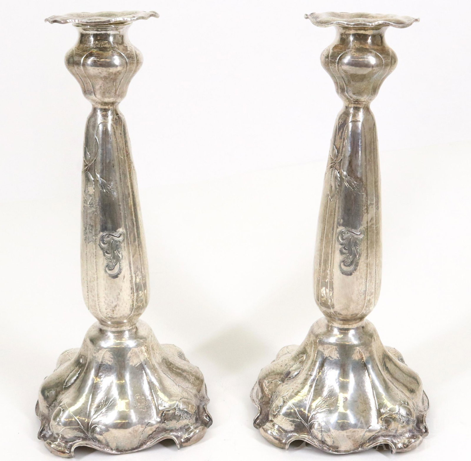 Gorham Martele Silver Candlesticks: Art Nouveau hand wrought .9584 silver pair of candlesticks, with scalloped and lobed bases, floral decoration, and removable bud form sconces, monogrammed. Some surface scratches noted. 11"h x 5"