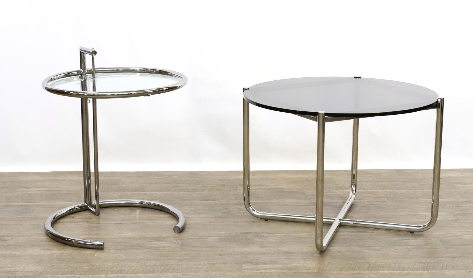 After Eileen Gray and Marcel Breuer End Tables: Complementing chrome steel tubular end tables both with circular tops with the Gray table having clear glass with an adjustable top and the Breuer table having a smoke glass top. Gray table&