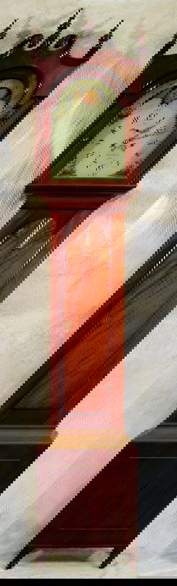 Tall Case Clock – Henry Wismer.: Cherry tall case eight-day clock having moon dial, second hand and date, fruit-design spandrels, carved rosettes, shell carved door, flush paneled bottom, turned feet, Henry Wismer, Bucks Co., PA, cir