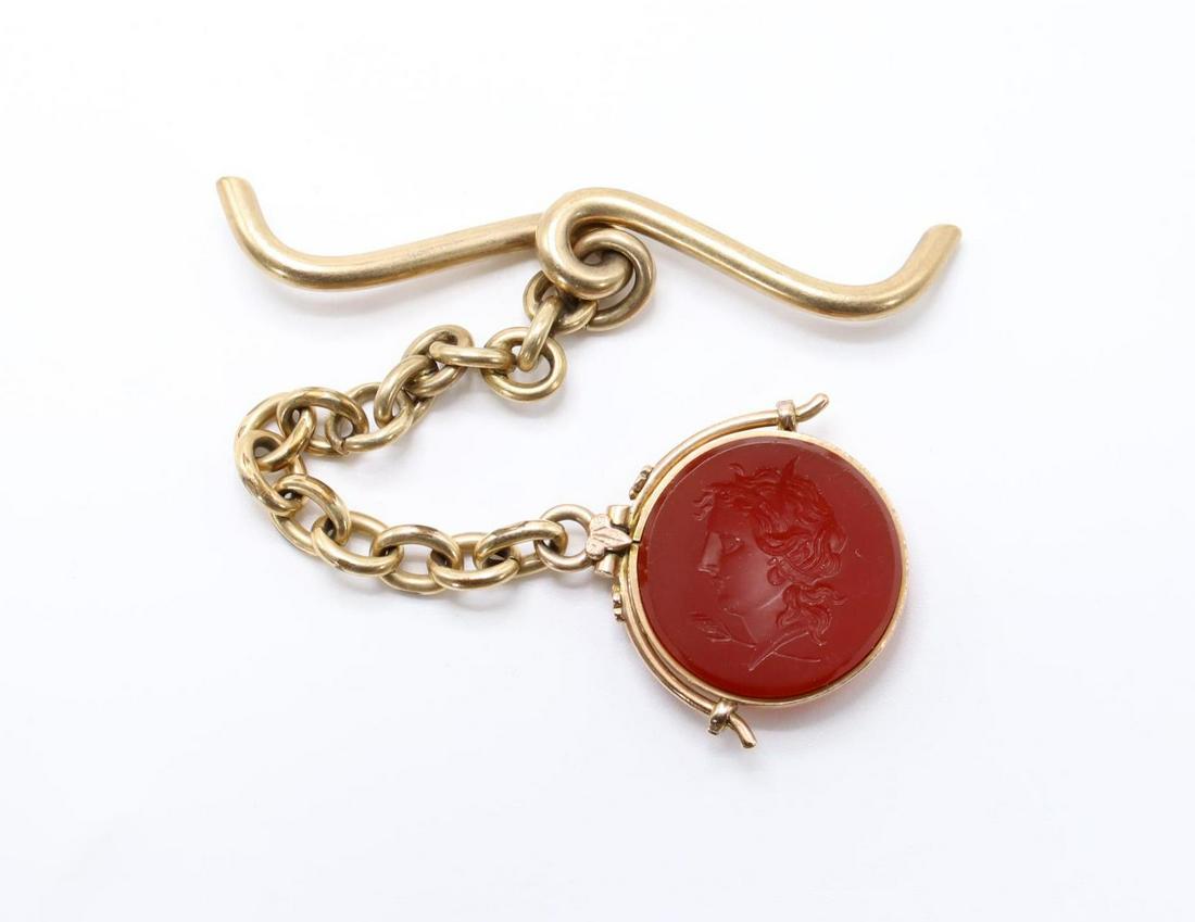 14K Rose Gold Carnelian Fob: Carnelian intaglio of a left facing profile, spins in its bezel. 3.5" overall length. 13.1gtw