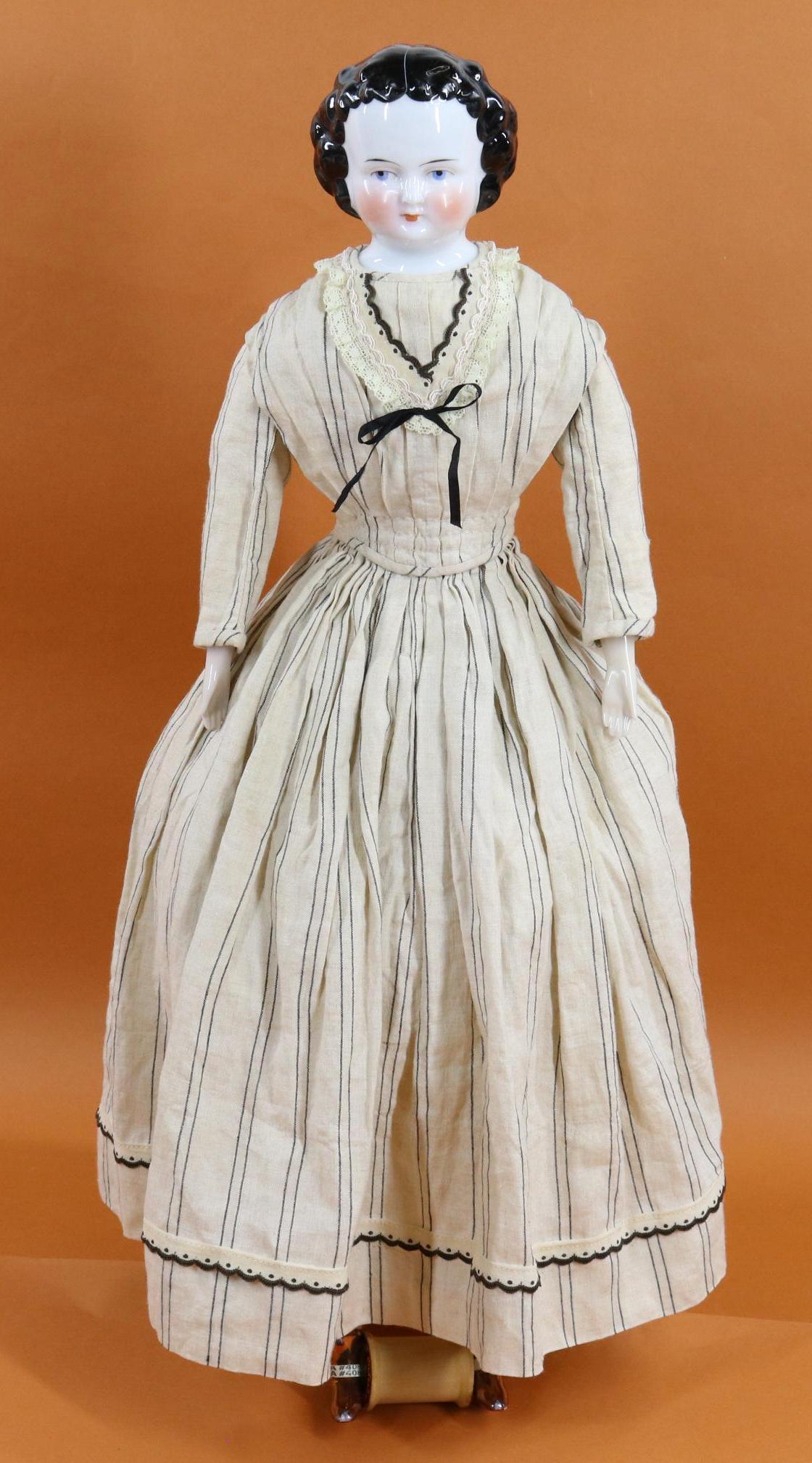 LOT OF CHINA DOLL(S).: 23" Antique unmarked china shoulder head doll. Black center part hair, blue eyes, rosy cheeks. China lower arms and legs with painted gold lustre boots. Replaced vintage cloth body. Dressed in all ant