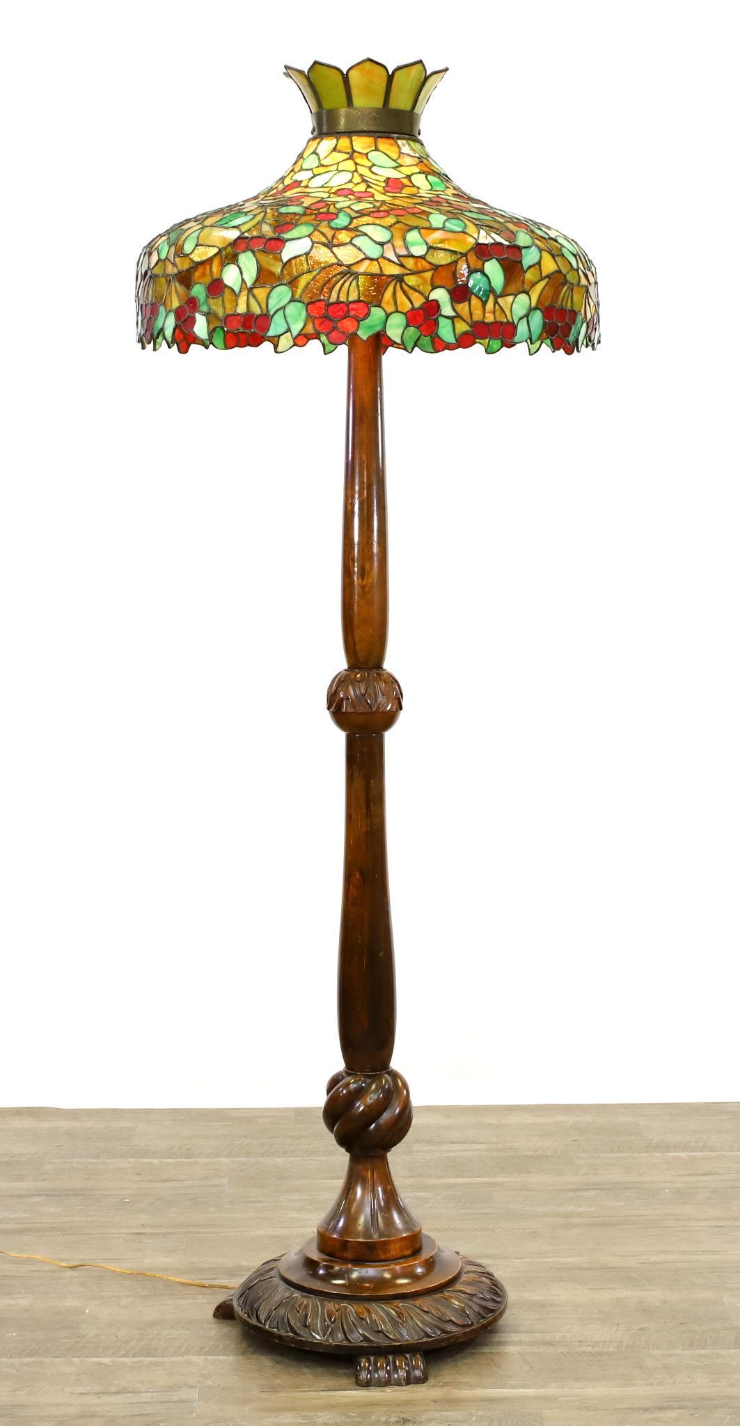 Leaded Slag Glass and Cherrywood Floor Lamp: Grape and vine leaded slag glass shade with a foliate decorated stem on paw feet. 69"h x 24"w (shade) **Please Note: This item is NOT eligible for in-house shipping. Please refer to the terms and cond