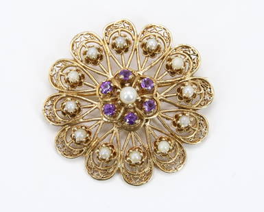 14KY Gold Amethyst and Pearl Brooch Pin: Amethyst and pearl brooch in 14ky gold features filigree petals with seed pearls and a center pearl haloed by faceted round amethyst. 1.625" round with a locking c-clasp. 13.6gtw