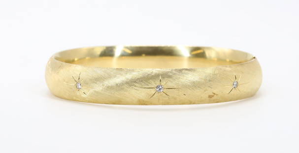 14KY Gold Diamond Bracelet: Bracelet of 14ky gold features round single cut diamonds, (3), set in starbursts with polished rays on a textured hinged bangle. 10.5mm wide, 2.25" x 2" i.d. 14.9gtw