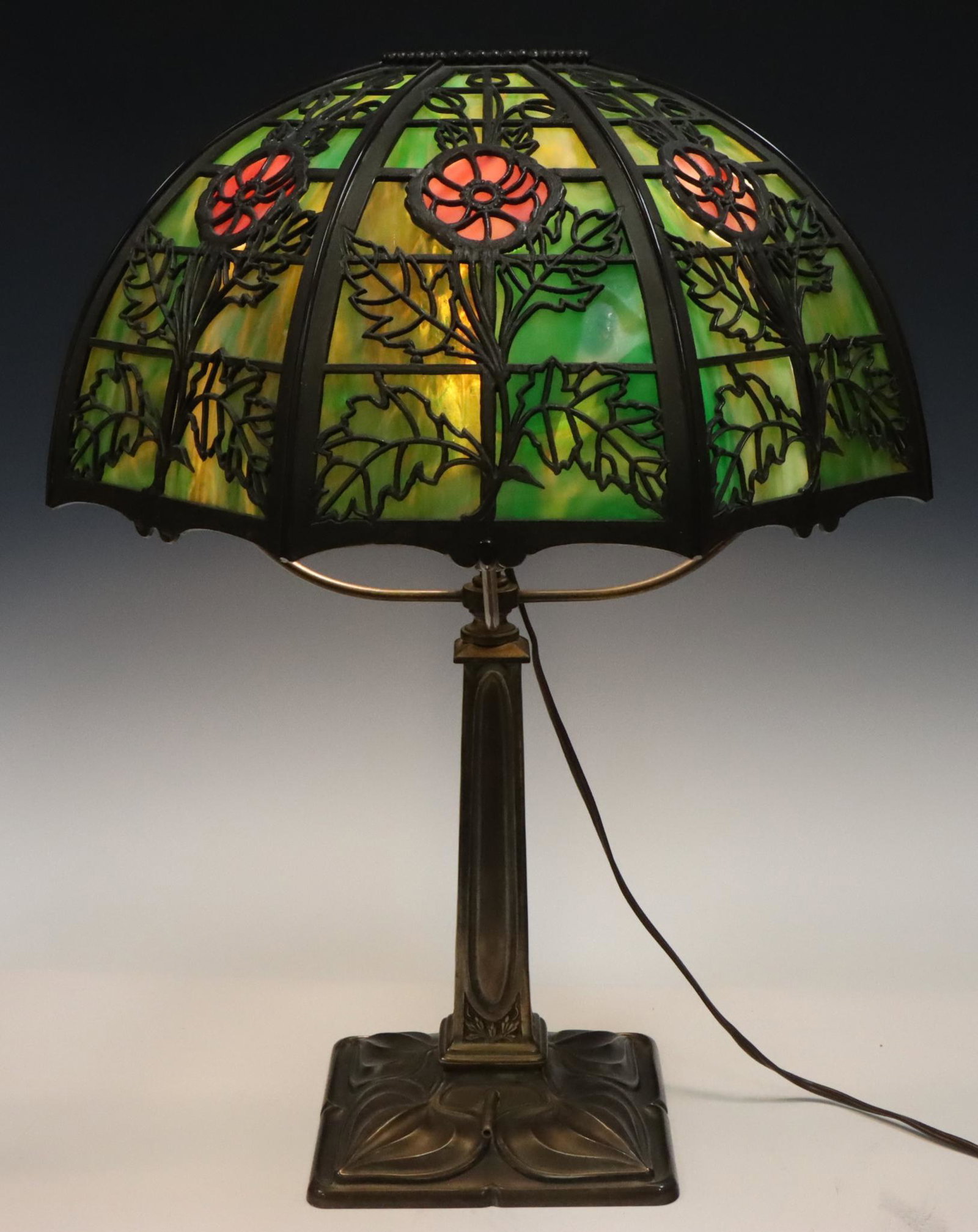 Slag Glass Lamp: Converted gas lamp with mixed metal base and slag glass shade with bronze frame. Turns on. 21”h x 16.5”w **Please Note: This item is NOT eligible for in-house shipping. Please refer to the
