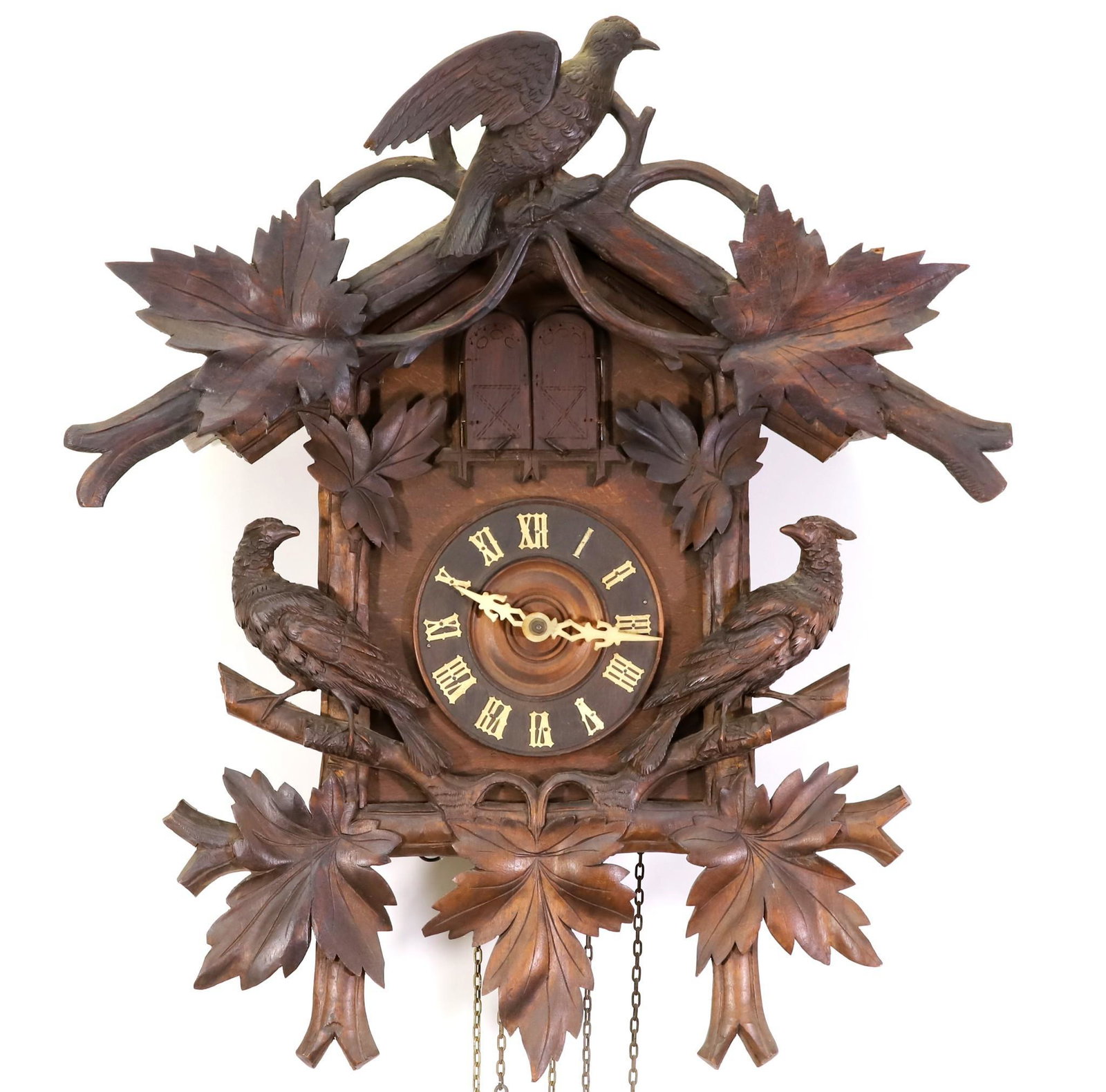 Black Forest Cuckoo Clock: German double cuckoo clock with carved pheasants and foliate decoration, first half 20th c. The clock face with celluloid Roman numerals and hands, below double doors holding a cuckoo and accordion pl