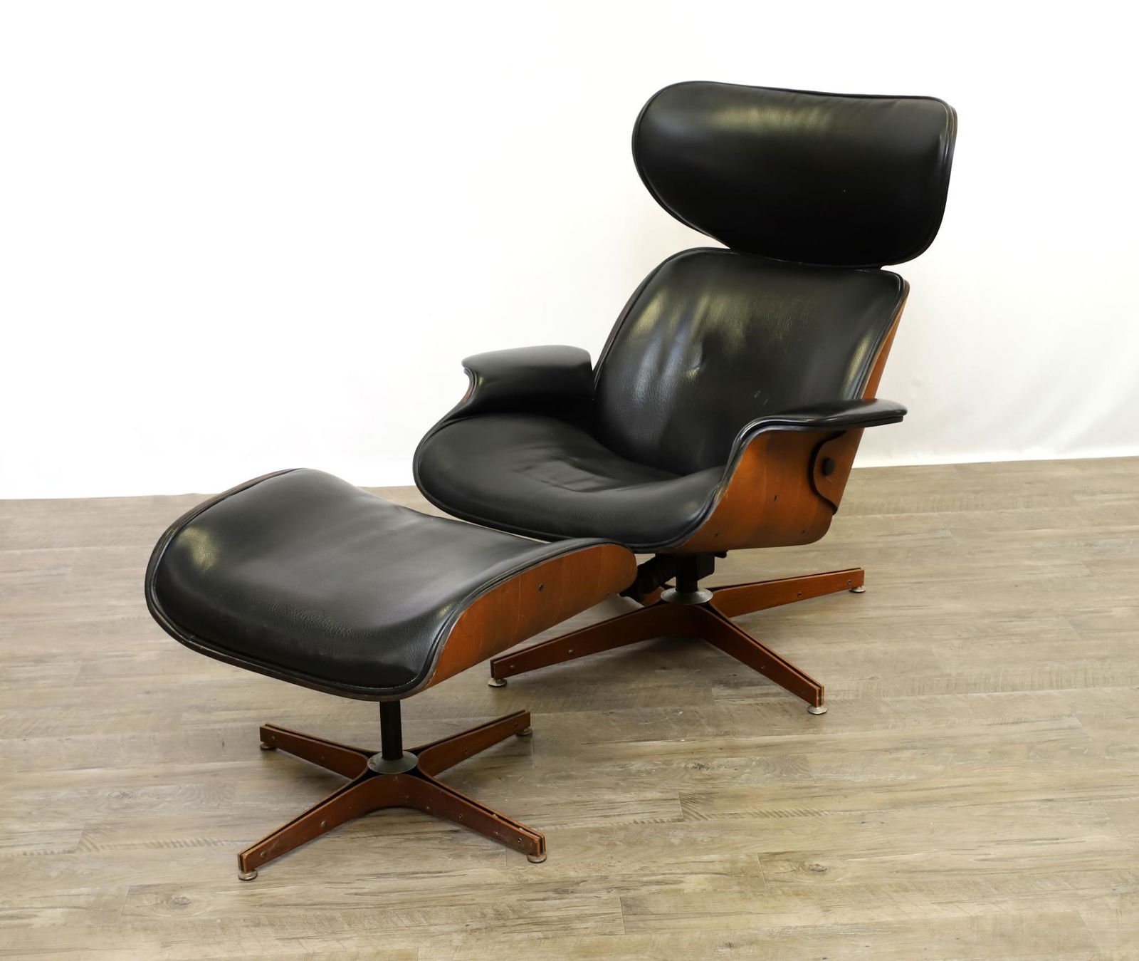 George Mulhauser for Plycraft Lounge Chair and Ottoman: Mid-century modern lounge chair and ottoman with bent walnut shell and black vinyl upholstery. 38"h x 31"w x 20"d, 14" seat height. Ottoman, 14"h x 24"w x 19"d **Please Note: This item is NOT eligible