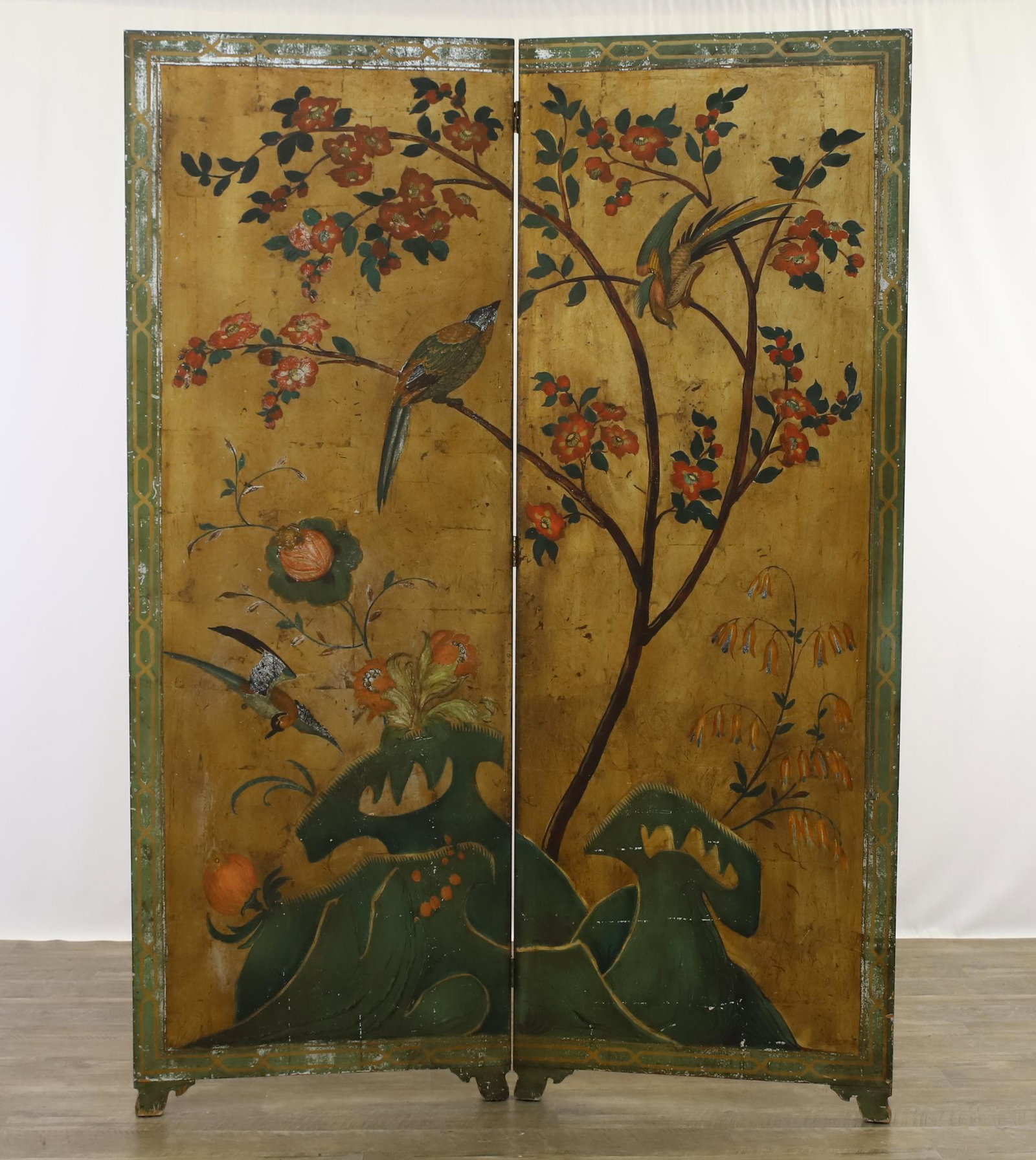 Chinese Hand Painted and Gilt Dressing Screen: Two panel screen with exotic aviary, floral, and foliate motifs on shaped legs. Screen exhibits areas of loss to the paint. 70"h x 50"w **Please Note: This item is NOT eligible for in-house shipping. 