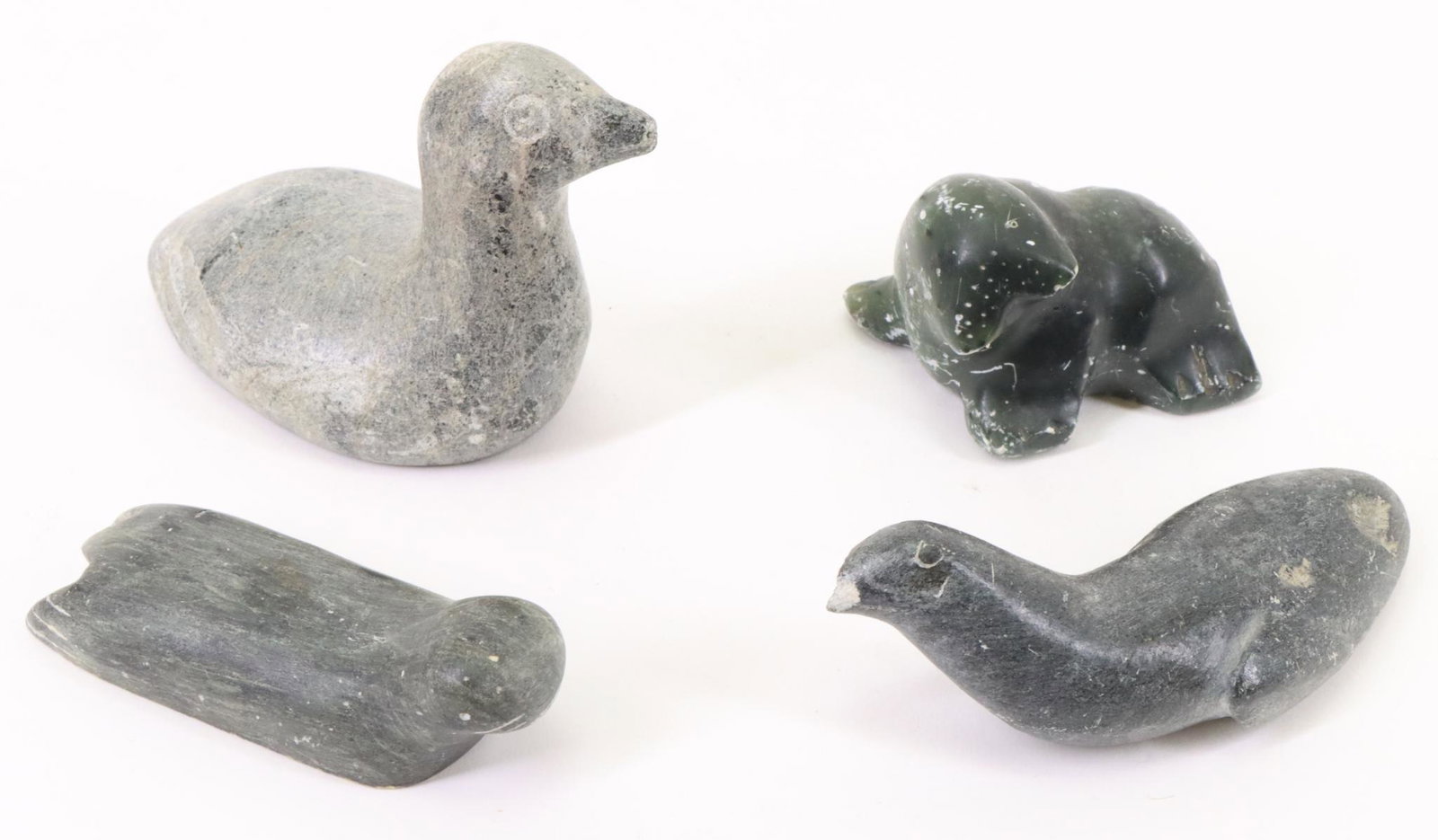 Inuit Carvings: Bird with long neck with Canadian Eskimo Art label, stylized walrus signed, laying seal signed and bird. Largest measures 3”h x 5”w