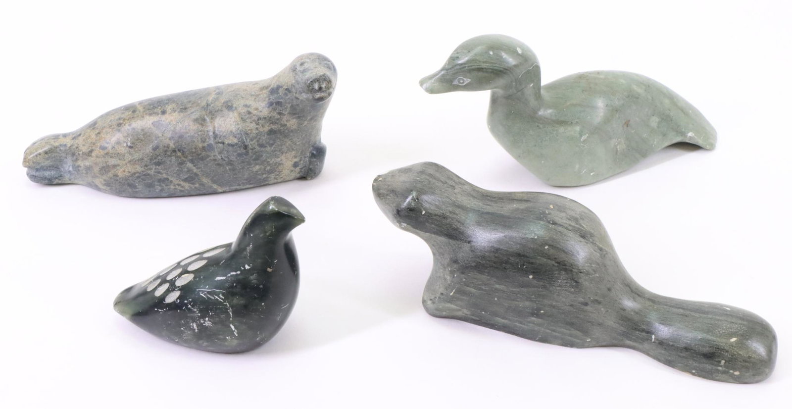 Inuit Carvings: Inuit carvings of a seal, brown beaver and sea bird, all signed. Also includes a seal that retains Canadian Eskimo Art label. Largest measures 2.5”h x 6”w