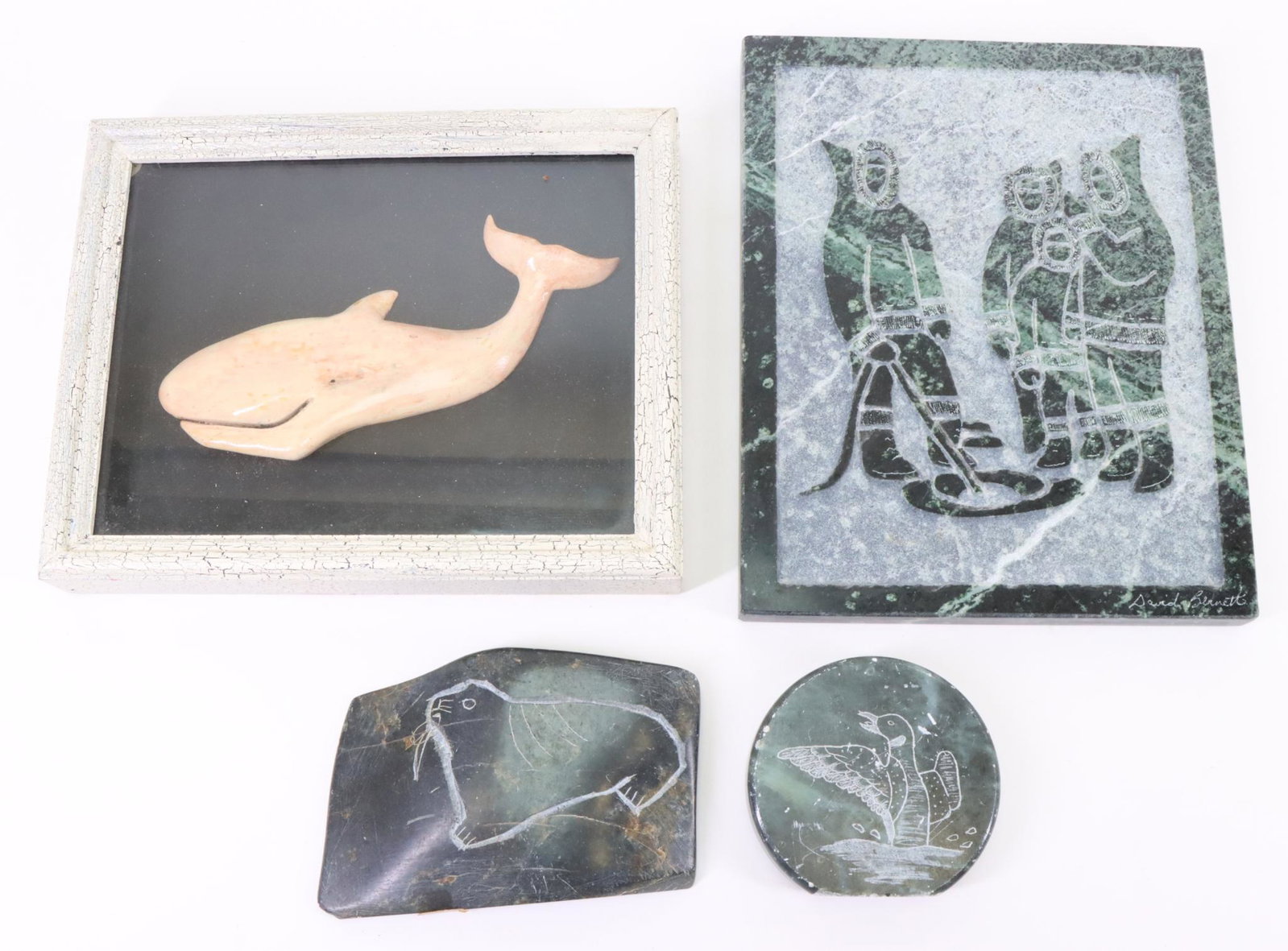 Inuit Carvings: Inuit carvings. Including standing Eskimos ice fishing by David Bernett, whale shadowbox, round etching of a duck and a two sided plaque with a seal and otter. Largest measures 10”h x 8”w