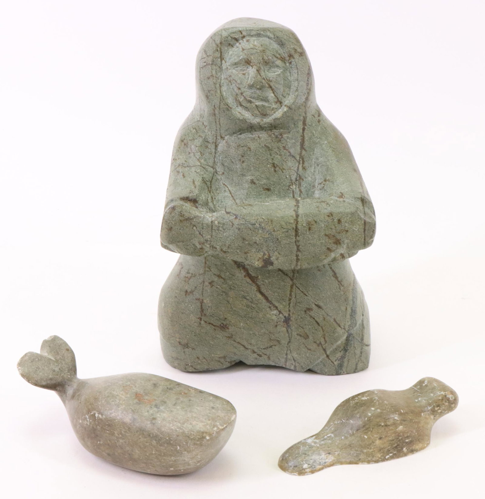 Inuit Carvings: Inuit carvings (3). Includes a kneeling Eskimo holding a fish, retains partial Canadian Eskimo Art label. Carving of a beaver, signed. Carving of a whale, unsigned. Largest measures 9”h x 5.5&rd