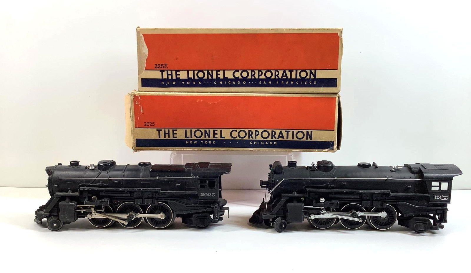 Lionel Trains 225E and 2025 Locomotives: Prewar, O gauge, 2-6-2 locomotive 225E, and postwar, O27 gauge, 2-6-2 locomotive 2025 with red and gold Keystone on boiler front, both with original boxes.