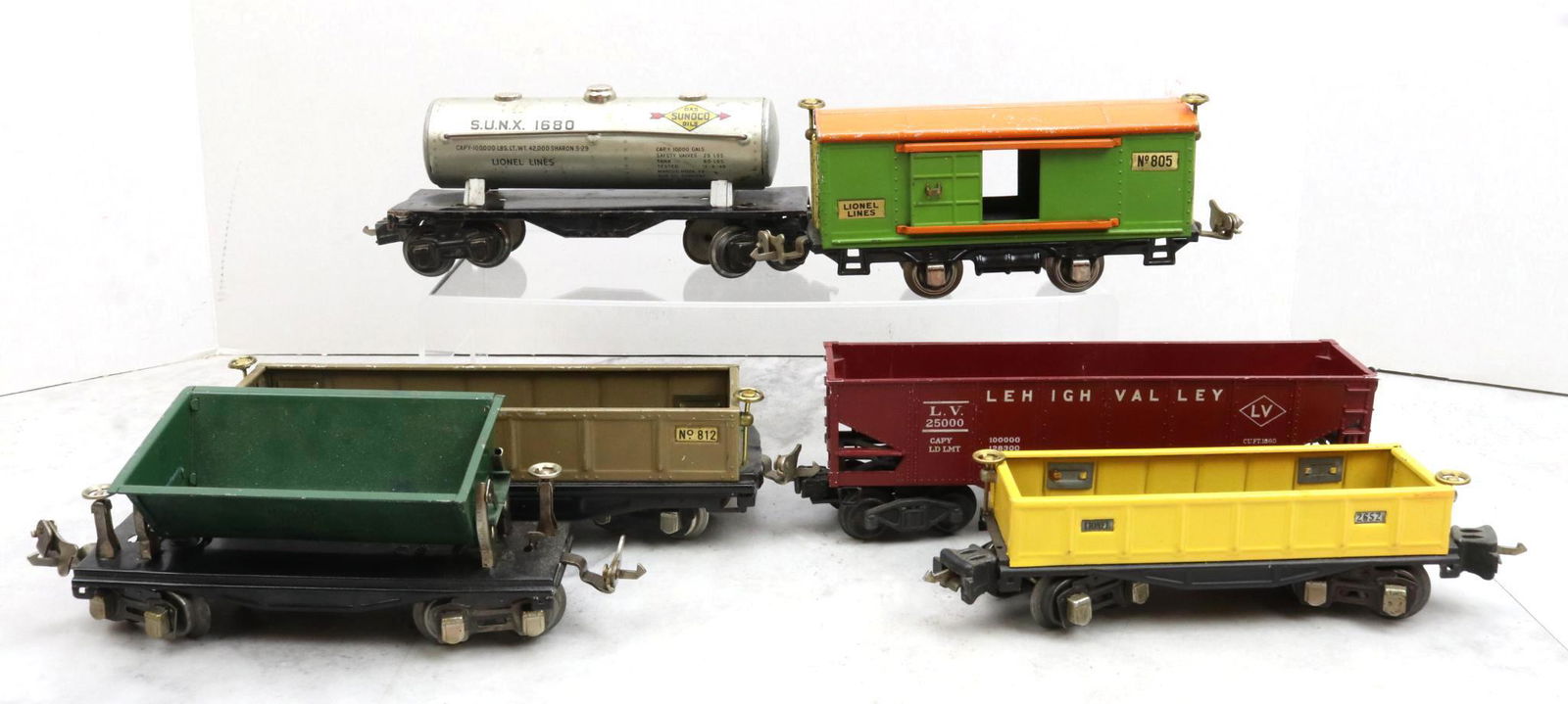 Lionel Trains Prewar and Postwar Cars: Prewar, O gauge, Sunoco tank car 1680, boxcar 805, gondola 812, ore dumping car 659, and gondola 2652. Postwar, O gauge, hopper 6456.