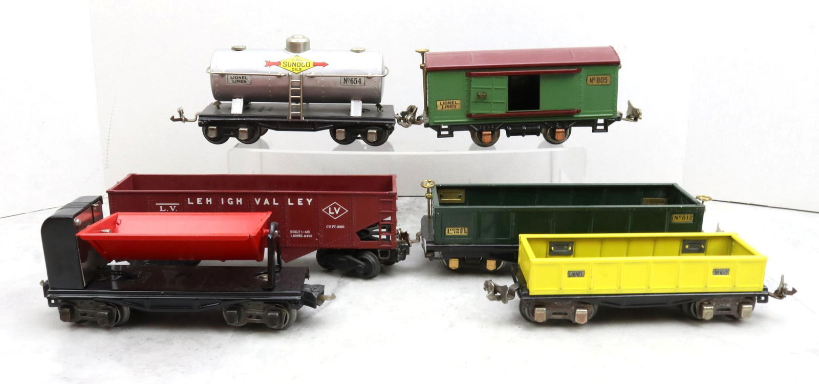 Lionel Trains Prewar and Postwar Cars: Prewar, O gauge, Sunoco tank car 654, boxcar 805, gondolas 652 and 812, and ore dumping car 3659. Postwar, O gauge, Lehigh Valley 25000 hopper 6456.