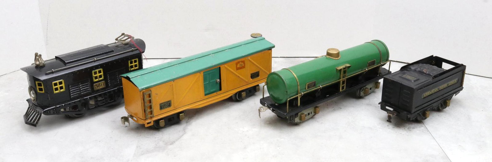 American Flyer Train Locomotive, Tender, and Cars: O gauge, 0-4-0 electric locomotive 3011, tender 3189, tank car 3210, and boxcar with Schrader Industrial Products label. Some of the American Flyers in this collection are reproductions or restoration