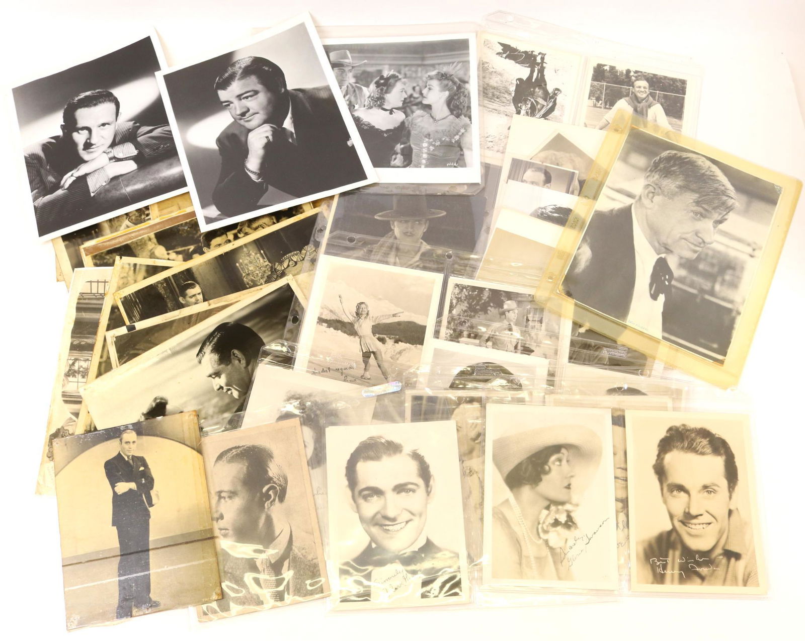 Movie Star Photographs: Collection of 45 photographs of movie personalities from the 1930's thru 1960's measuring 5" x 7" up to 8" x 10". Some photographs present facsimile autographs. Images include John Wayne, Humphrey Bog