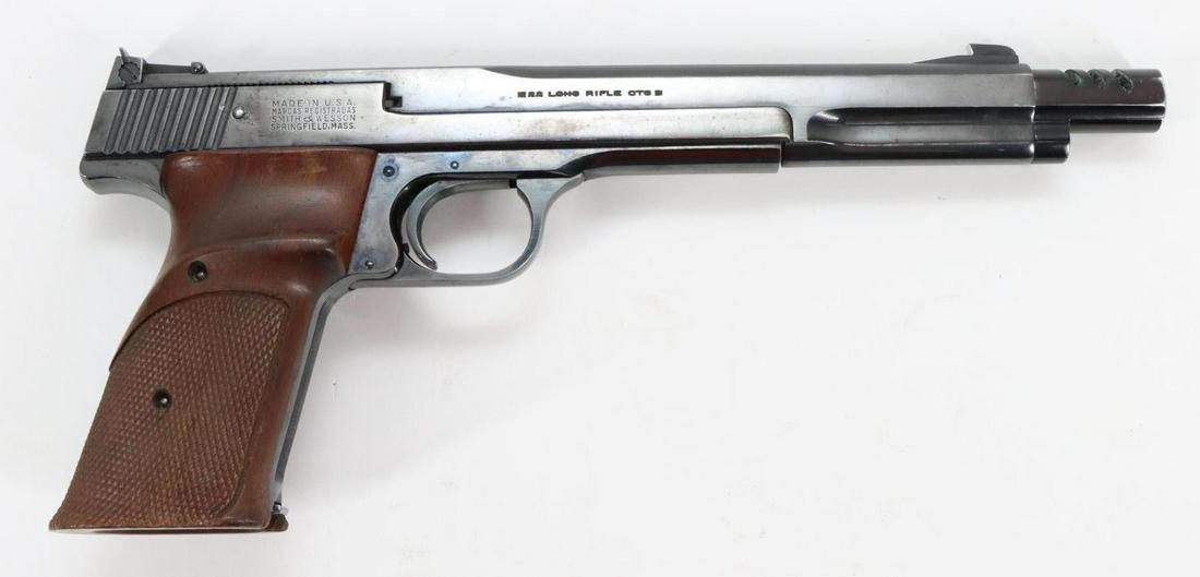 Smith & Wesson Model 41 Semi Automatic Pistol: 22LR, 7" bbl with compensator, SN 10796. 95% blue finish shows average handling with minor scratches and small areas of light freckling, good bore, adjustable sights, checkered wood thumb rest grips s