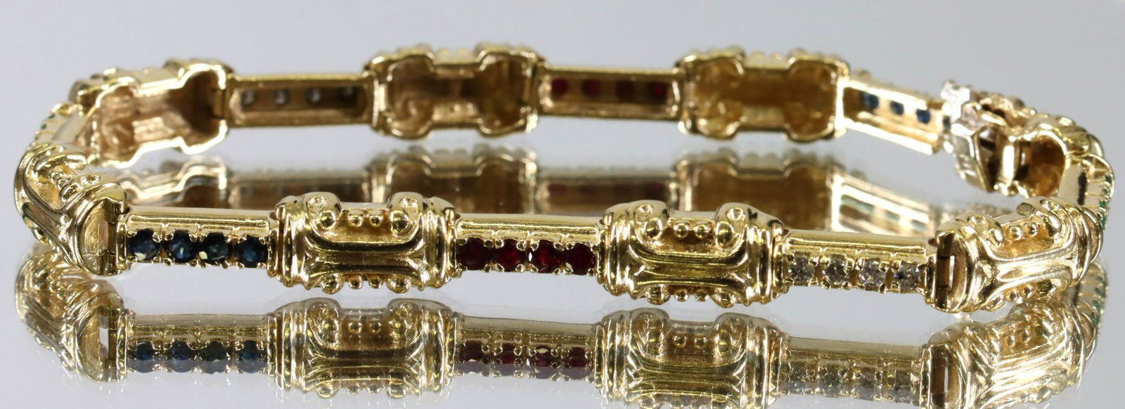 Gold Ruby Sapphire Emerald Diamond Bracelet: Bracelet in 14ky gold features faceted round rubies, sapphires, and emeralds, with round faceted diamonds. Coloured gemstones in dark tones are moderately included, (24) approx. 1.44ctw; diamonds are 