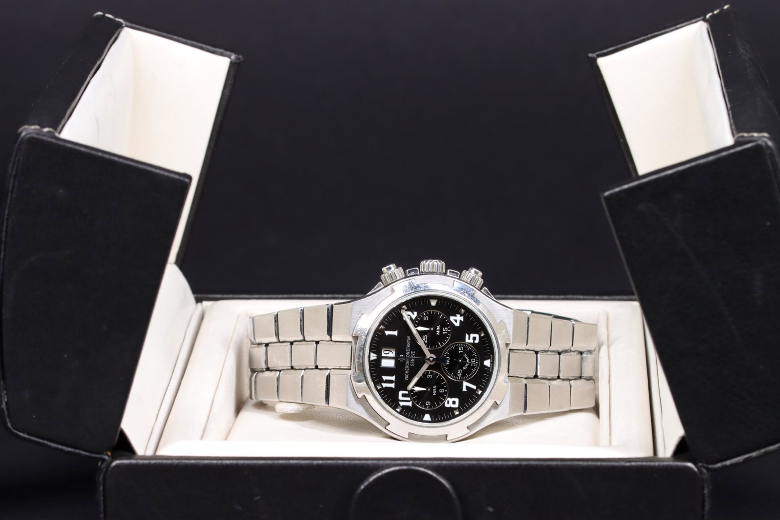 Vacheron Constantin Overseas Chronograph: Vacheron Constantin Overseas chronograph features a black dial with luminescent hands and Arabic numerals, hour, minute, and second subdials, plus a date register at 12. 729618 15atm. 40.0mm wide stai