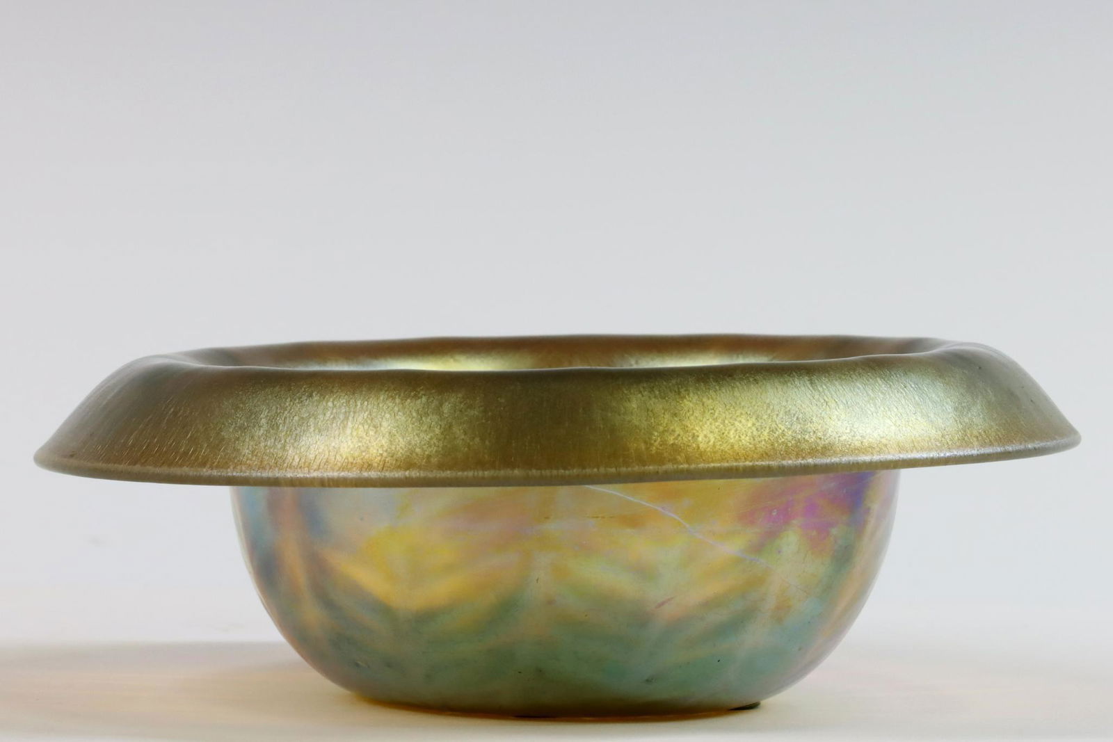 Tiffany Studios Gold Favrile Bowl: Tiffany Studios bowl with feather accents and a vibrant gold iridescent finish with purple, pink and blue highlights. Etched signature to base, L.C. Tiffany Favrile, 1883. Retains original Tiffany Stu