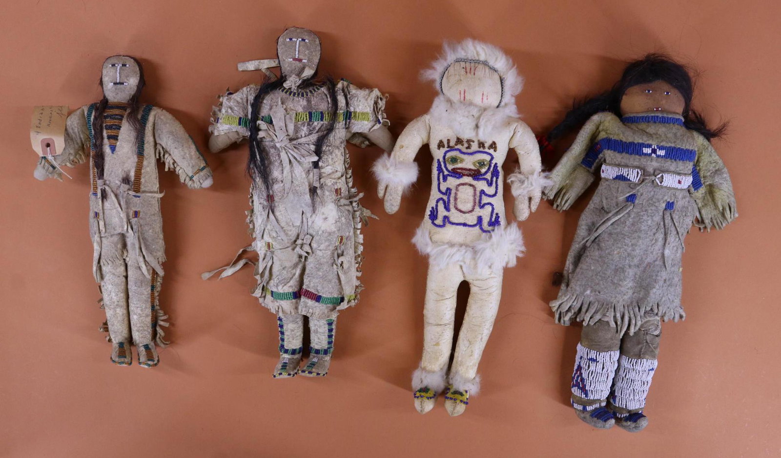 NATIVE AMERICAN DOLL(S).: LOT. (4) Original dolls with leather clothing, beautiful beadwork detail. (3) Have beaded features and human hair wigs. Pair - 13" male and 14 1/2" female with cloth bodies. 15" "Alaska" doll is all l
