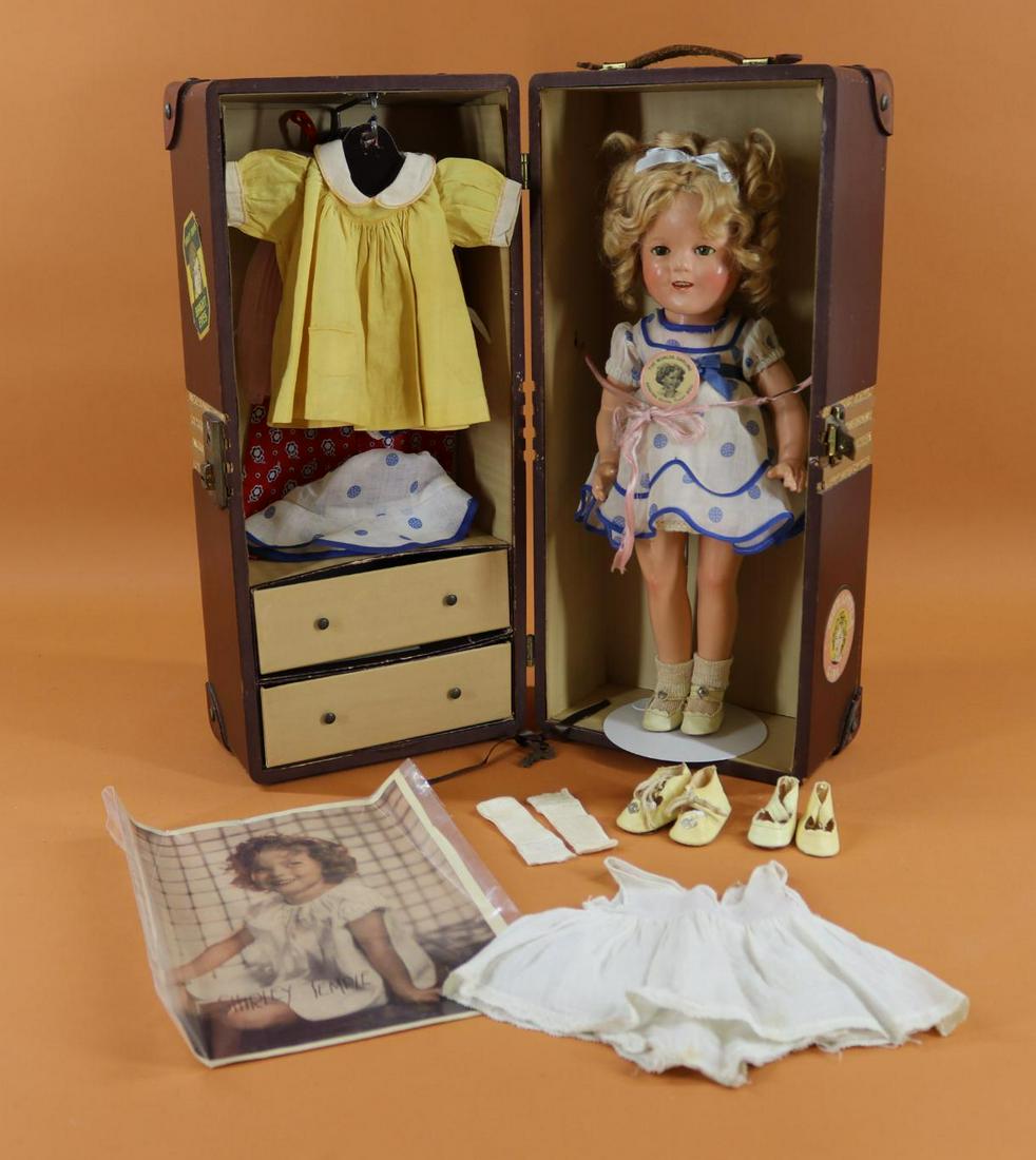 SHIRLEY TEMPLE.: LOT. 16" Ideal composition doll with original mohair wig. Doll comes with (3) tagged outfits and an unmarked dress, 2 pc. sunsuit. Extra 1 pc. under garment, (3) prs. of shoes, (2) prs. of socks. "The