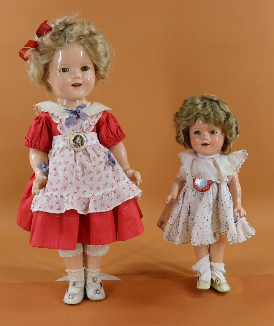 SHIRLEY TEMPLE.: Pair of Ideal composition dolls with original wigs. 13" Doll is dressed in clothing of the period, oilcloth shoes. Original "My Friend Shirley Temple" pin. Condition: crazing, hair is uncombed. She st