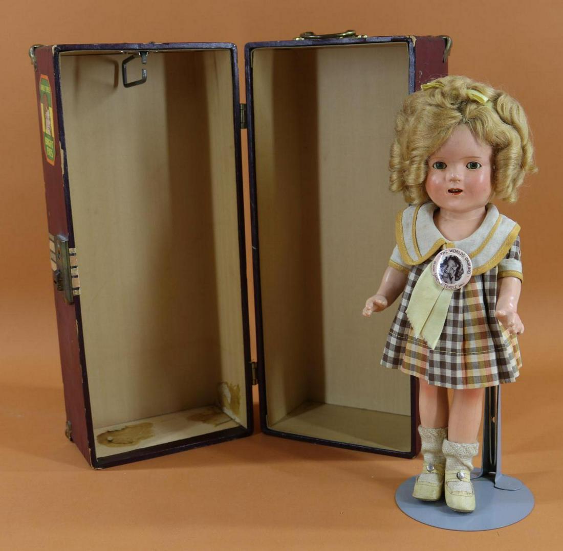 SHIRLEY TEMPLE.: LOT. 13" Ideal composition doll with honey blonde mohair wig. Dressed in all original clothing - brown/orange plaid dress, 1 pc. undergarment, ivory oilcloth shoes, rayon socks. Original "The World's 