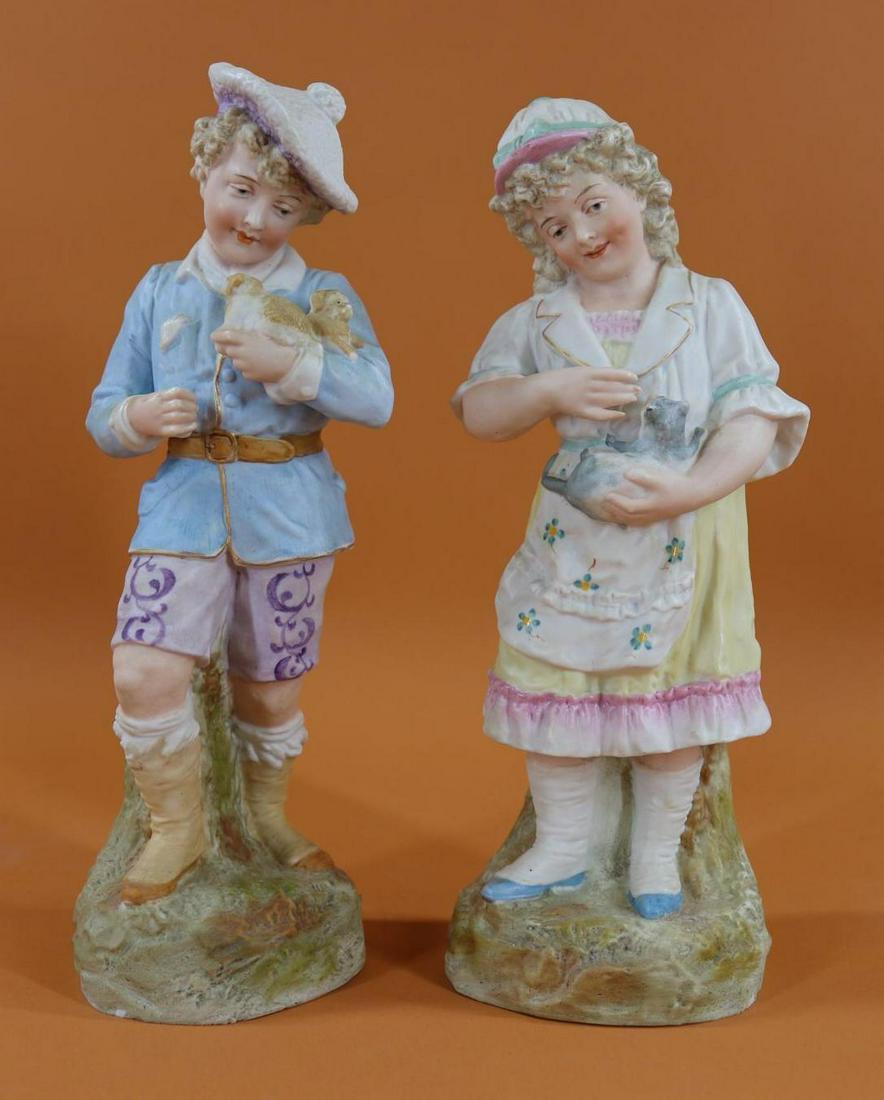 BISQUE FIGURINES.: Pair of HEUBACH Children "Holding Their Pets". Marked with Heubach Sunburst. Both have intaglio eyes. 12" Female holding her Kitten. Condition: tiny chips on rim edge. Kiln cracks on interior. 12" Mal