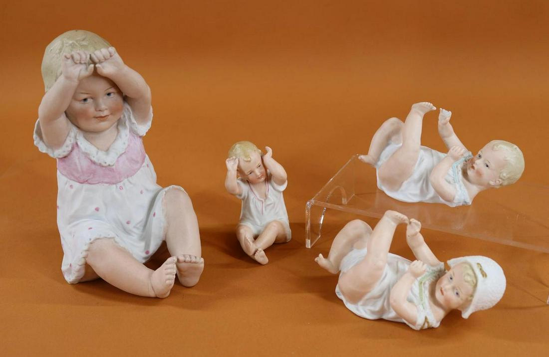 BISQUE FIGURINES.: Lot of (4) German "Piano Babies" with intaglio eyes. 8" Sitting baby marked 3801. Condition: nothing observed. The following (3) Babies are marked with the HEUBACH Sunburst. 5 1/2" Baby on back. Condi