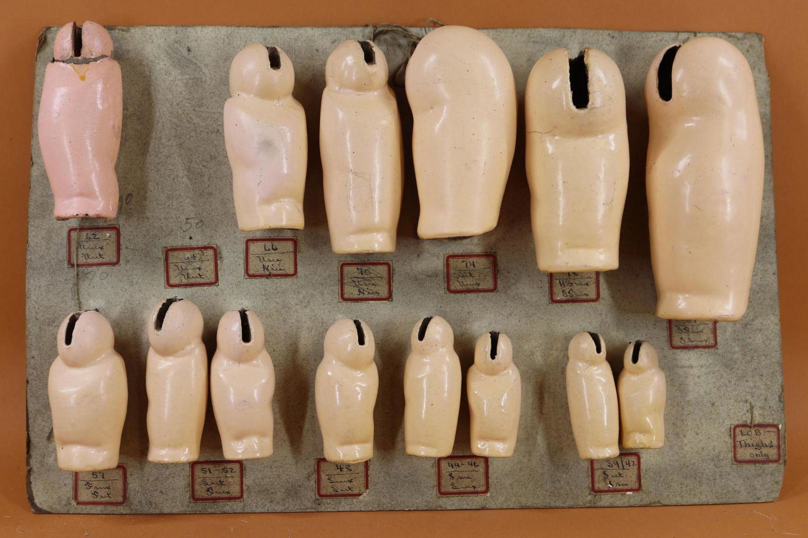 SALESMAN'S SAMPLE CARD - GERMAN BODY PARTS.: Lot of German papier mache parts from a 1930's Philadelphia doll hospital - (14) THIGH leg sections. 3" - 8". Condition: (1) Has been replaced (repaired) and (2) appear to be missing. This lot is bein