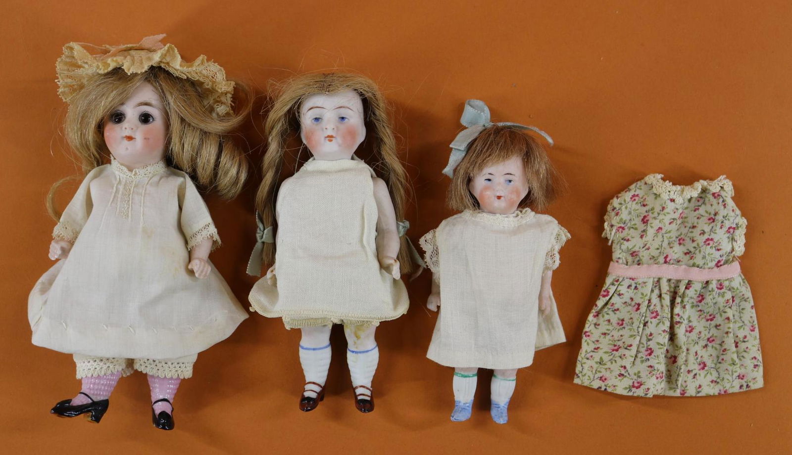 ALL BISQUE DOLLS.: LOT of (3) dolls with closed mouths, human hair wigs, 5 pc. bodies, painted/molded shoes. They are all dressed in antique/vintage white clothing. (2) Painted ey dolls - 5" 5023 with blue shoes. Wire s