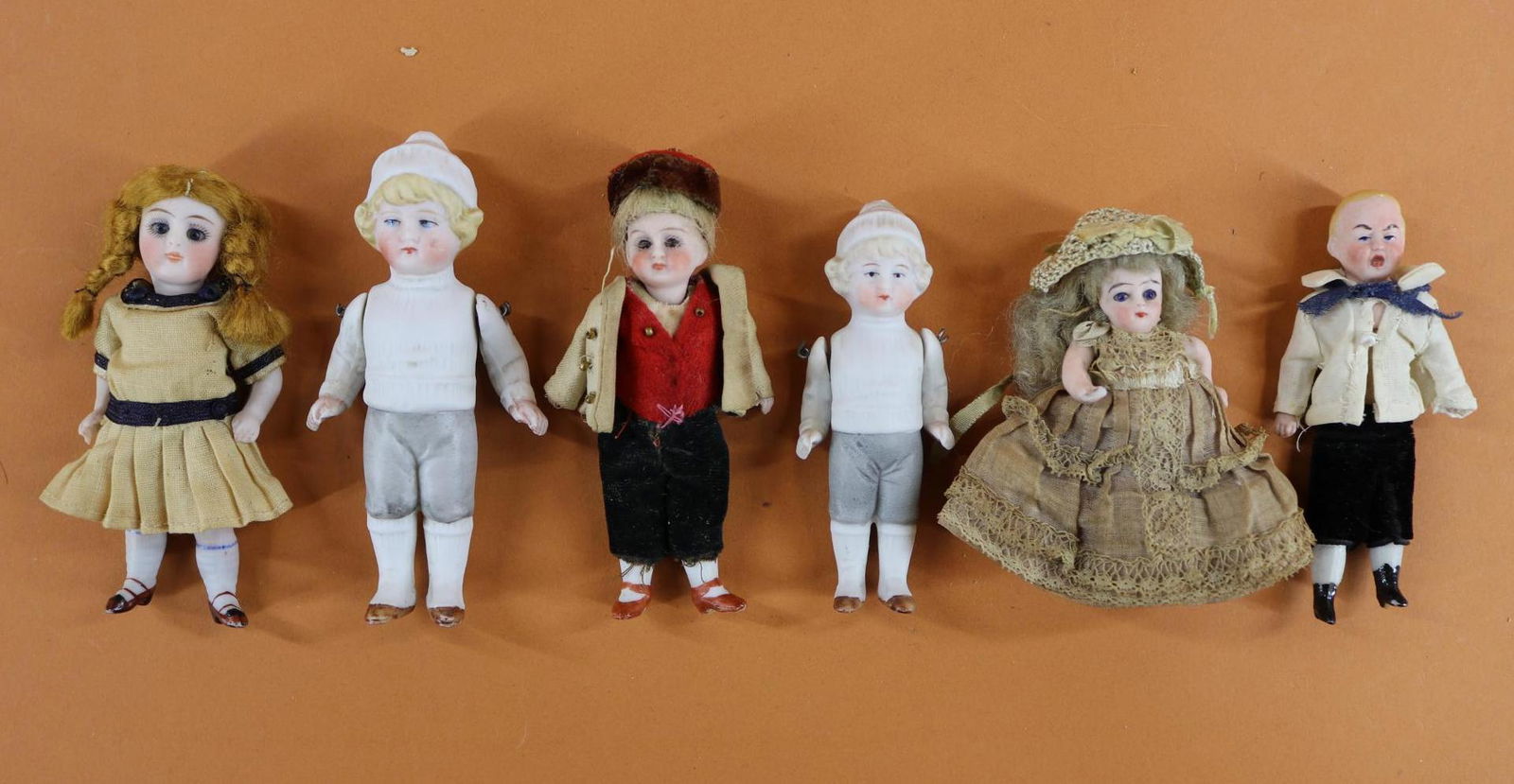 ALL BISQUE DOLLS.: LOT of (6) dolls. Pair of boy dolls with painted features, hair, clothing. Wire strung arms. 3 1/2", 4 1/4". (3) Dolls with stationary glass eyes, mohair wigs, antique clothing. 4" Boy with swivel hea