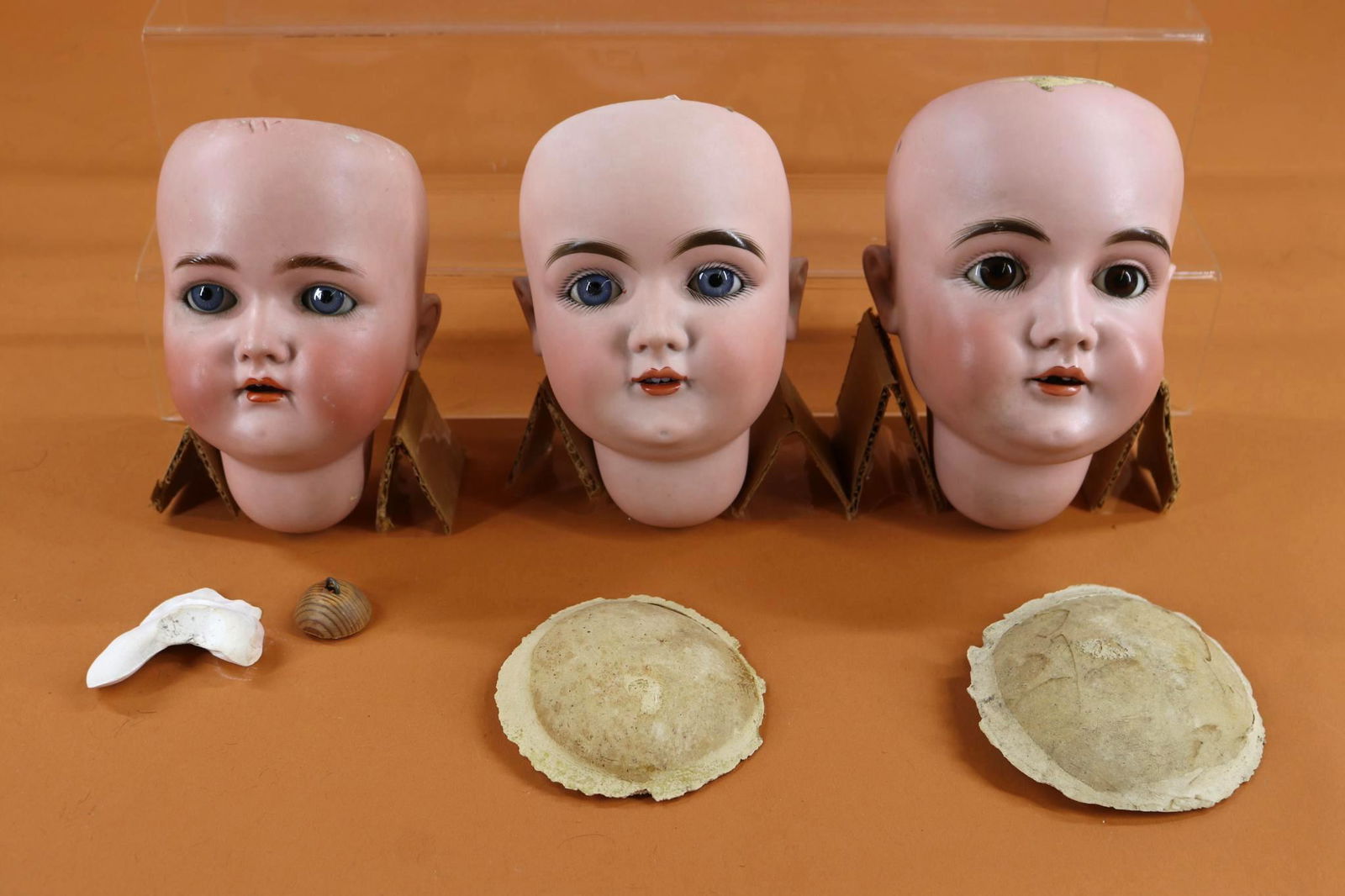 LOT OF DOLL SUPPLIES.: LOT of antique bisque DOLL HEADS from a Philadelphia doll hospital. Lot of (3) heads. NO wigs. KESTNER - L 1/2 MADE IN GERMANY 15 1/2. 13 1/2" Circ. Blue sleep eyes. Neck button. Plaster pate. (Right