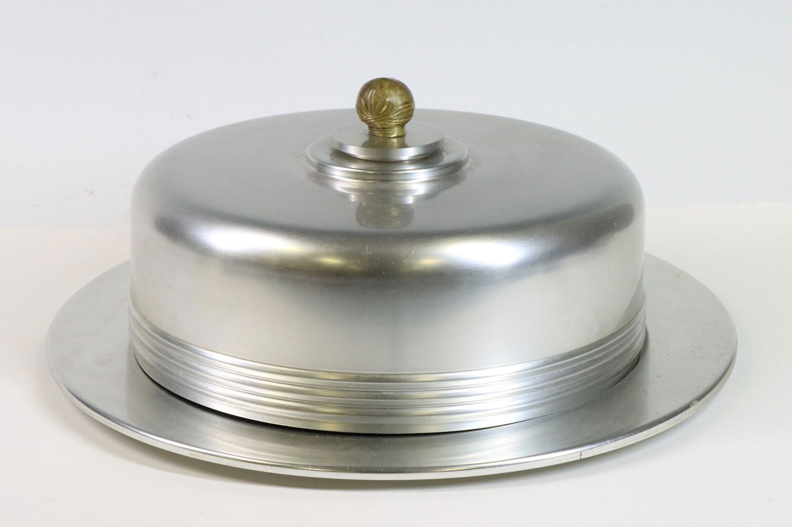 Kensington Aluminum Covered Tray: Art Deco covered tray designed by Lurelle Guild. Aluminum domed lid with brass knob, tray and round wooden insert. Marked on bottom. 6.5"h x 15.25" round