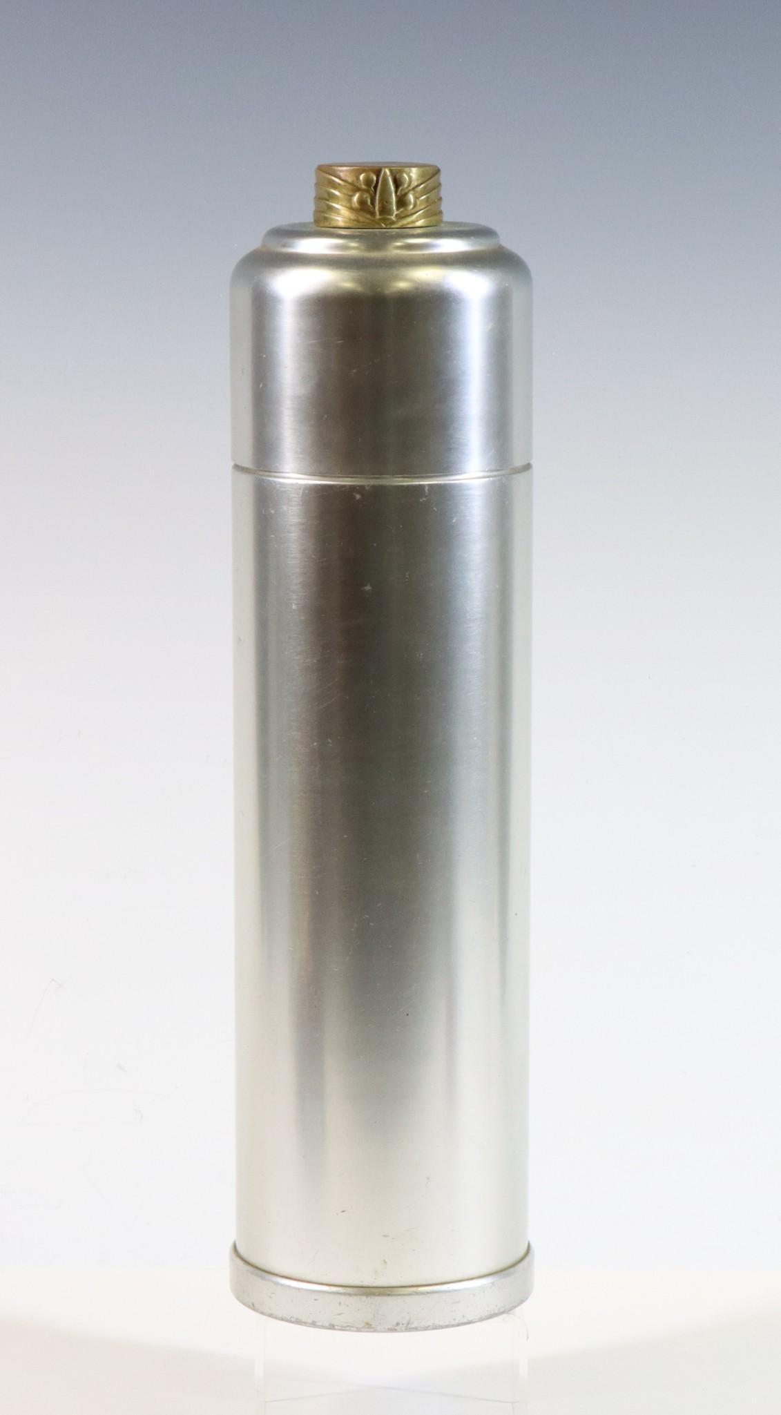 Kensington Aluminum Cocktail Shaker: Art Deco cocktail shaker designed by Lurelle Guild. Aluminum body with brass finial. Includes shaker, lid, drain, and cork with aluminum cap. Marked on bottom. 13.5"h x 3.5" round