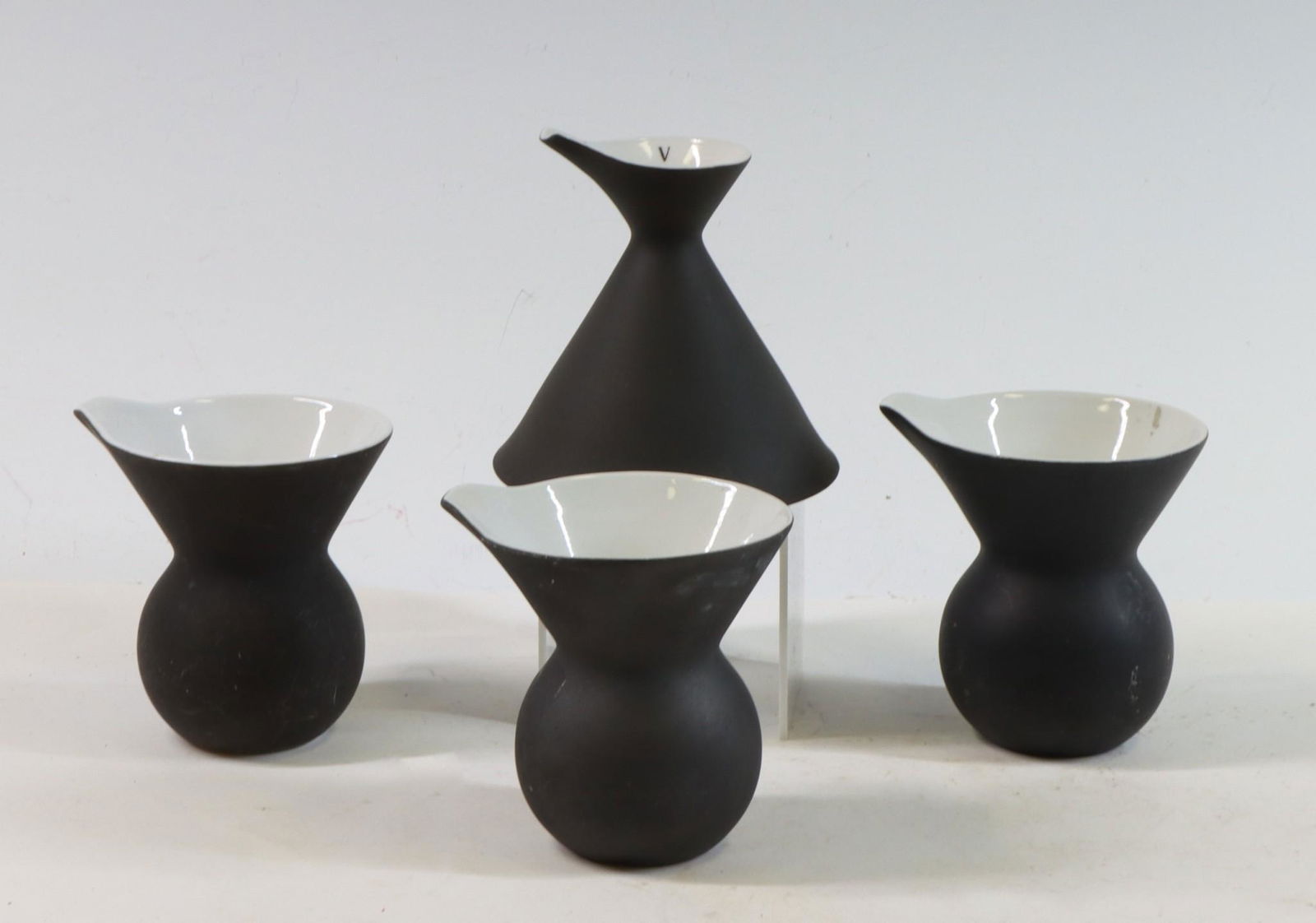 Kenji Fujita for Freeman Lederman: Kenji Fujita for Freeman Lederman tableware having matt black bodies and white interiors. Small pitchers/creamers (3) 4"h and funnel shaped vinegar cruet, 4"h. Each piece marked Freeman Lederman